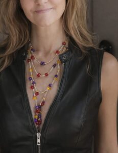 Mujer luciendo el Collar Modelo Trricolor con chaqueta de cuero.