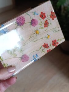 Caja de madera decorada con flores en colores vibrantes.