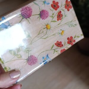 Caja de madera decorada con flores en colores vibrantes.
